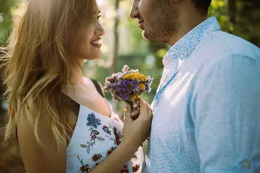 Paar - Mann überreicht Frau Blumen