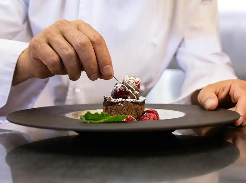 Koch richtet Dessert an.