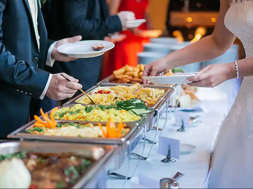 Servierkraft mit 2 Tellern und gebratenen Garnelen auf Salat.