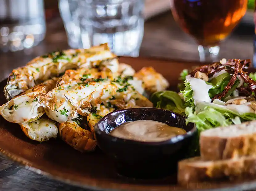 Teller mit gegrillten Garnelen, Salat und Cocktailsauce.