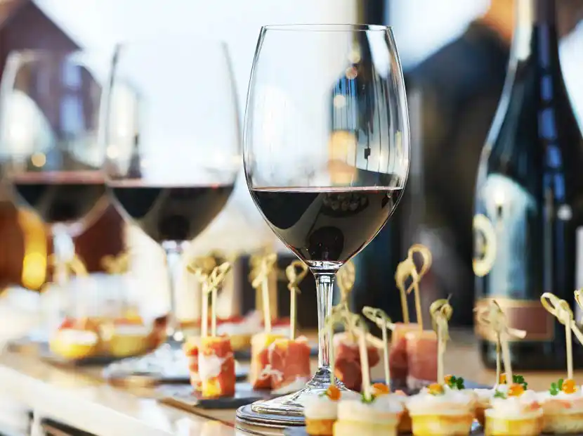 Buffettisch mit Rotweingläsern und Fingerfood/Canapés.