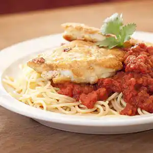 Teller mit Spaghetti, Schnitzel und Tomatensauce.