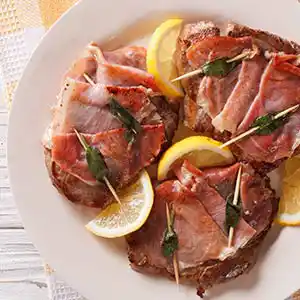 Teller mit Kalbsschnitzel, Schinken und Salbei.