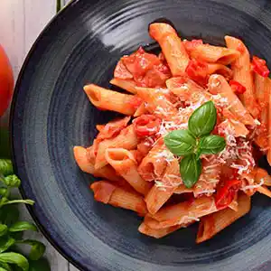 Teller mit Nudeln und scharfer Tomatensauce.