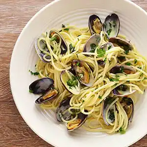 Teller mit Nudeln, Muscheln und Meeresfrüchten.