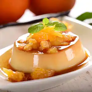 Teller mit Panna Cotta Karamell, Orangen-Filets und Minze.