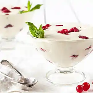 Teller mit Zabaione, Himbeeren und Minzgarnitur.