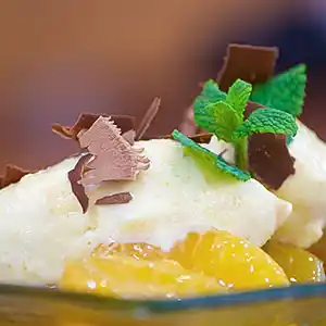 Weißes Schokomousse auf Orangenkompott mit Schokosplitter.