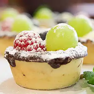 Mürbteigförmchen mit Crème-Chantilly und Obst.