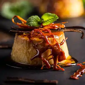Crème Caramel mit Karamelnetz und Minzgarnitur.