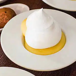 Crème von eingelegten Zitronen mit Baiser im Schälchen.