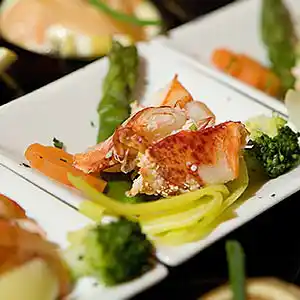 Schälchen mit Krabbenfleisch auf Spargel-, Broccholi-, Zucchini-Karotten Beet.