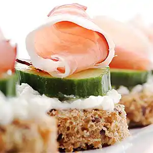 Südtiroler Speck auf Brottaler an Gurken-Hüttenkäse-Beet.