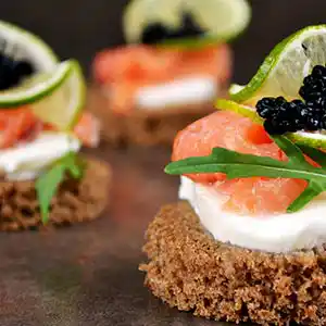 Geräucherter Lachs auf Vollkorntaler mit Mozzarella und Kaviar.