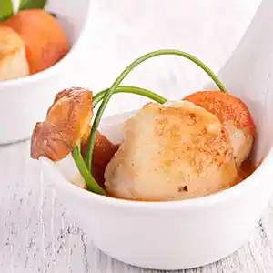 Löffel mit gebratener Jakobsmuschel mit Pfifferlingen.