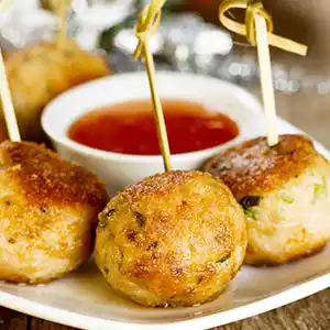 Gebratene Fisch-Gemüse-Bällchen mit süß-saurem Chilidip am Spieß.