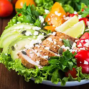 Blattsalatteller mit Paprika, Tomaten, Avocado und Hühnerbrust.