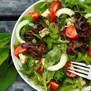 Blattsalatteller mit Rucola Zwiebeln, Tomaten, Schafskäse.