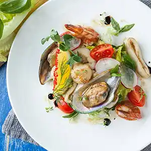 Meeresfrüchtesalatteller mit Tomaten und Radieschen.