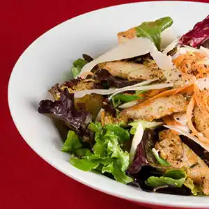 Teller mit verschiedenen Blattsalaten, Karotten, Parmesan und Croutons.