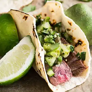 Wrap mit gebratenem Rindfleisch, Gurke und Limetten.