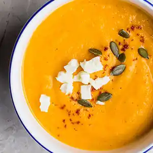 Teller mit Kurbiscrèmesuppe und Crème fraîche.