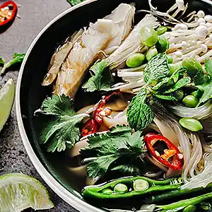 Teller mit chinesischer Glasnudelsuppe und Fisch.