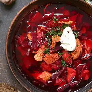 Teller mit Borscht und Crème fraîche.