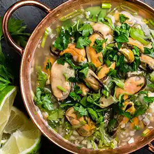 Teller mit Muschelsuppe und Petersilie.