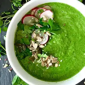 Teller mit Brunnenkressesuppe und Radieschen.