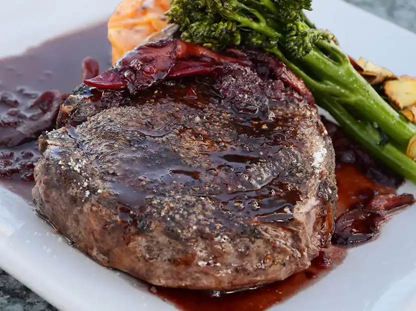 Teller mit gegrilltem Steak auf Broccoli und Bratkartoffeln.