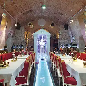 Uriges Gewölbe mit gedeckten Tischen.