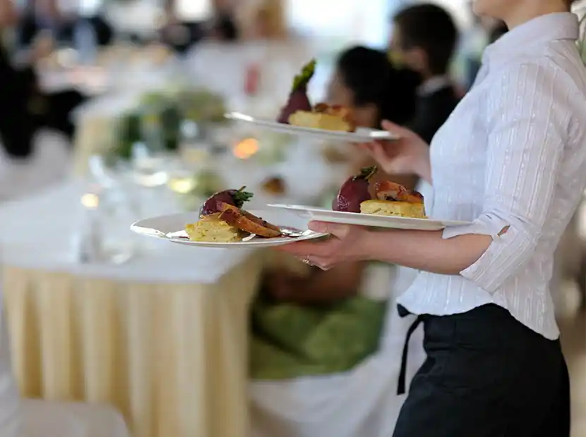 Servicekraft serviert das Menü.