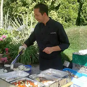 Servicekraft beim Grillen.