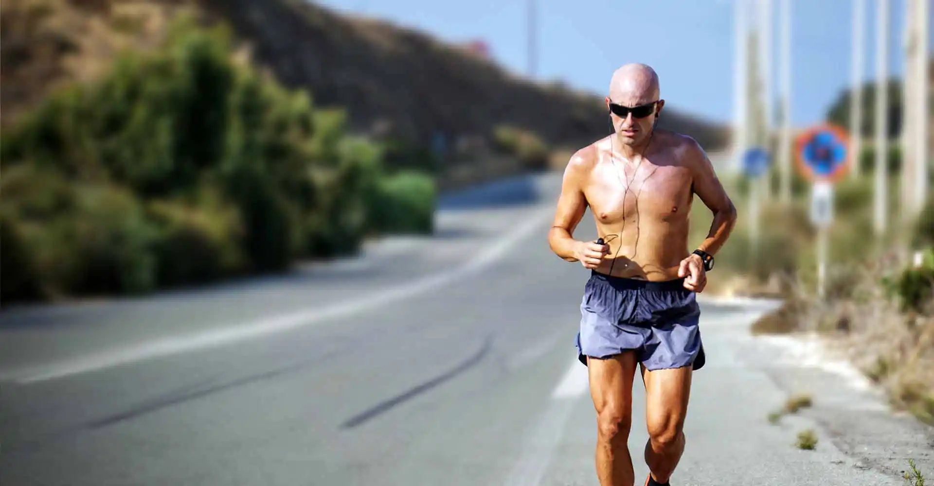 Mann mit nacktem Oberkörper joggt.
