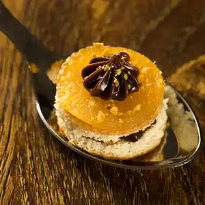 Bisquite gefüllt mit Schokolade an Mandarinenfilet im Löffel.