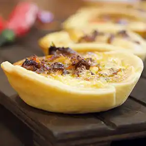 Mini-Quiche mit Speck, Eiern und Junglauch.