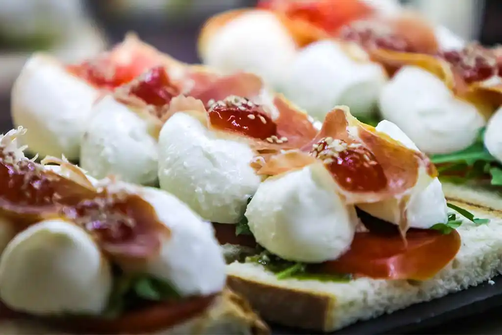 Mozzarella mit kross-gebratenem Parmaschicken und Himbeermousse auf Ruccola-Pesto-Ciabatta.