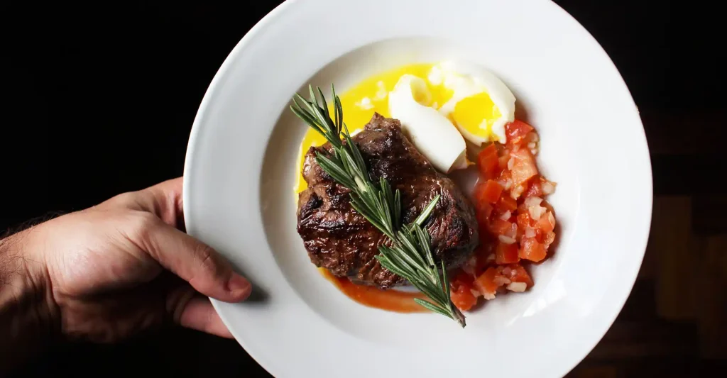 Teller mit Steak, Tomaten und Ei.