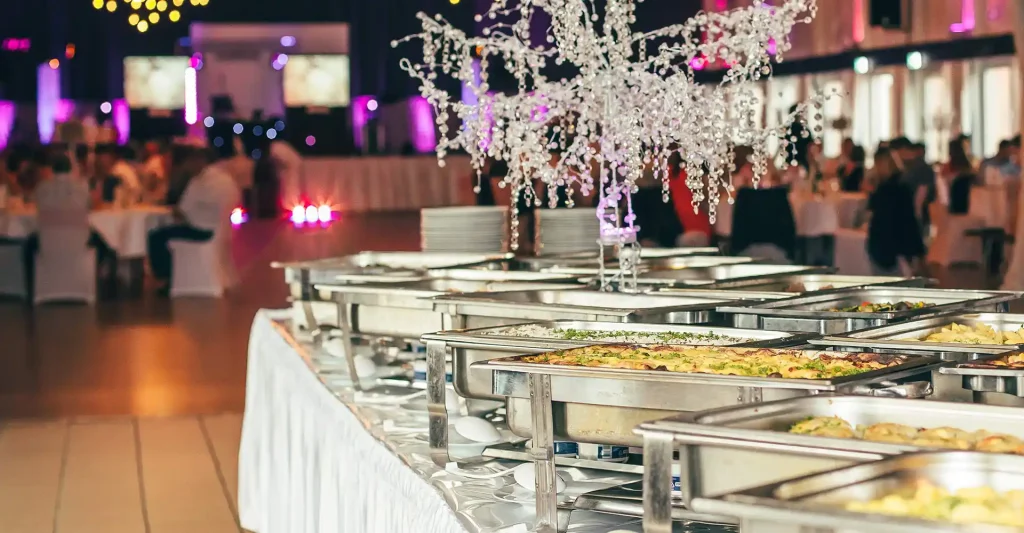 Saal mit Gästen und Buffet.