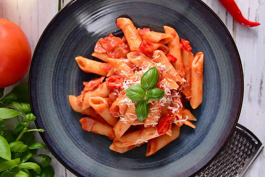 Teller mit Nudeln und scharfer Tomatensauce.