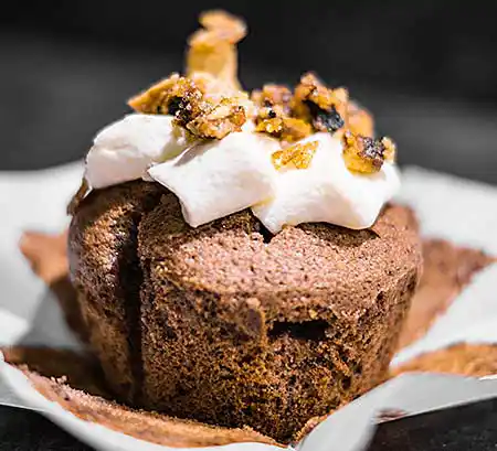 Cupcake mit Sahne Topping und karamellisierten Walnüssen.